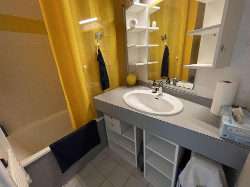 une salle de bain avec un lavabo et une baignoire dans l'établissement Studio face mer avec balcon et piscine chauffée, à deux pas du golf – 3 couchages - FR-1-224C-232, à Saint-Jean-de-Monts