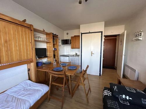 Cette chambre comprend une table, un lit et une cuisine. dans l'établissement Studio à 50m de la plage, 3 couchages, quartier estacade - FR-1-224C-281, à Saint-Jean-de-Monts