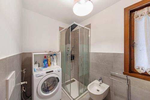 a bathroom with a washing machine and a sink at Ciasa Valentina in Auronzo di Cadore