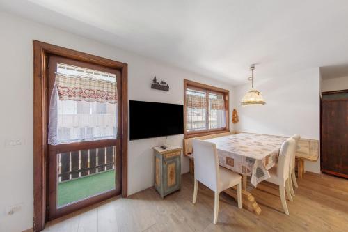 a dining room with a table and a television at Ciasa Valentina in Auronzo di Cadore