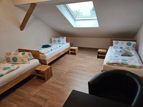 a attic room with three beds and a window at Ferienwohnungen März in Söchtenau