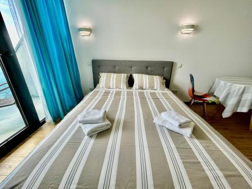 a bed in a room with two towels on it at Real Beach Tower in Batumi