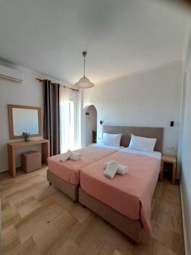 a bedroom with a large bed with two towels on it at Lord Complex in Agios Georgios
