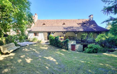 a house with a fence and a bench in a yard at Stunning Home In Plazac With Wifi in Plazac