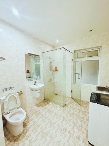 a bathroom with a toilet and a shower and a sink at Jakaranda Villa Dalat in Da Lat