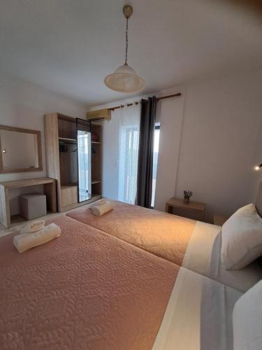 a bedroom with a large bed with two towels on it at Lord Complex in Agios Georgios