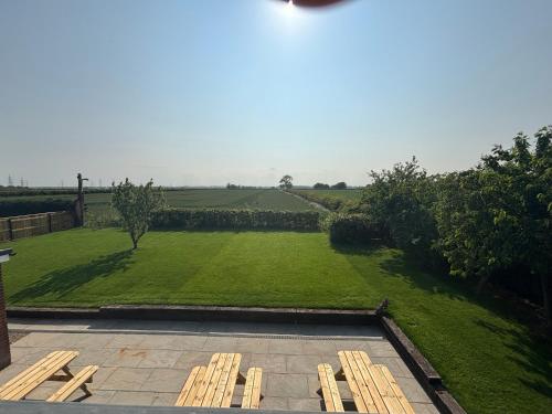a view of a garden with several wooden benches at East Halton Hotel in East Halton