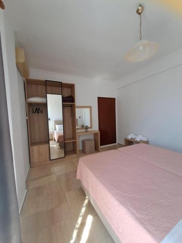 a bedroom with a bed and a mirror at Lord Complex in Agios Georgios