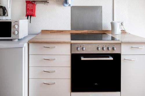 a kitchen with a black stove and a microwave at Fewo Cheny 2 mit 36qm in Titisee-Neustadt