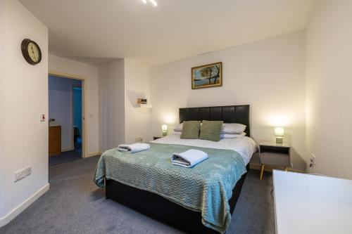 a bedroom with a large bed with towels on it at Dundee City centre apartment - 3 bedrooms sleeps 6 in Dundee