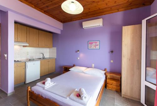 a bedroom with a large bed with purple walls at Alpha Studios in Nydri
