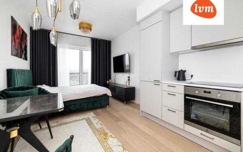 a white room with a bed and a kitchen at Luxury And So Comfortable Studio in Tallinn