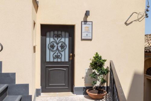 a black door on a house with a plant at Zeus Atabyrios 3 - Open Space in Agrigento
