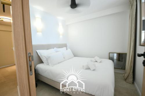 une chambre avec un lit avec des draps blancs et des oreillers dans l'établissement LE PORT VAUBAN for 4 by SUNSET RIVIERA HOLIDAYS, à Antibes