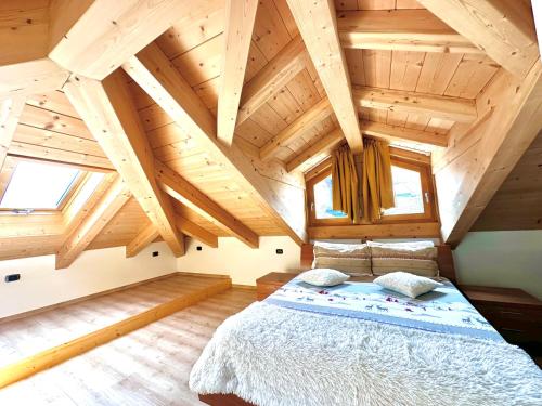 een slaapkamer met een groot bed in een houten huis bij Alpine Escape 6 in Bormio