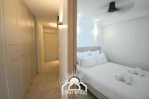 - une petite chambre avec un lit blanc et un couloir dans l'établissement LE PORT VAUBAN for 4 by SUNSET RIVIERA HOLIDAYS, à Antibes