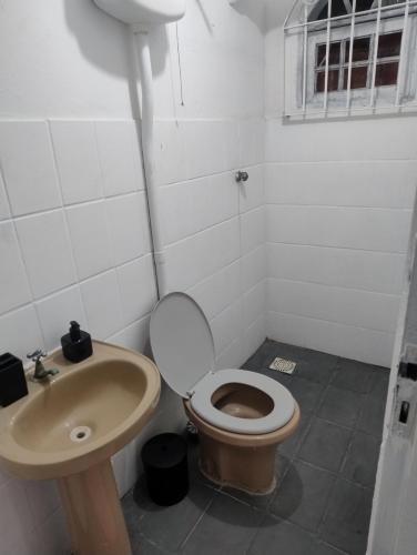 un baño con inodoro y lavabo en Hostel cabo frio, en Cabo Frío