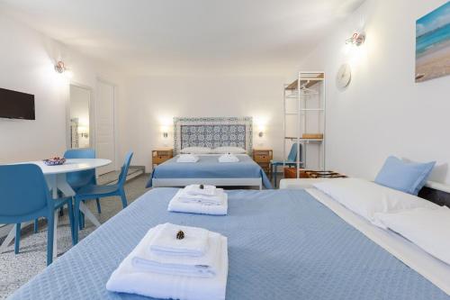 a bedroom with two beds and a table and chairs at Zeus Atabyrios 3 - Open Space in Agrigento