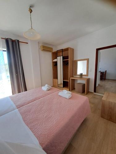 a bedroom with a large bed with two towels on it at Lord Complex in Agios Georgios