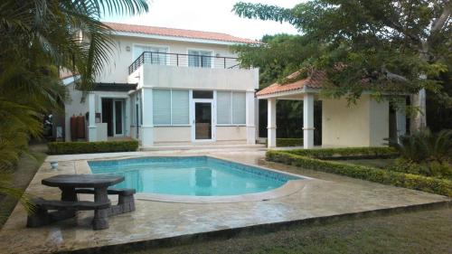 a swimming pool in front of a house at Villas Del Jardin 7 in Juan Dolio