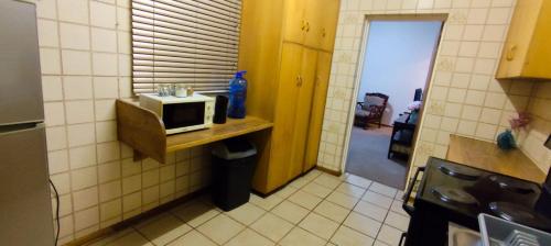 a small kitchen with a microwave on a counter at Die Potskerf in Bloemfontein