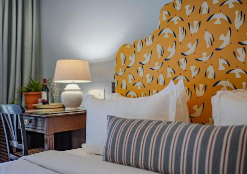 a bedroom with a bed and a table with a lamp at The Project Cafe and Hotel in Aldona