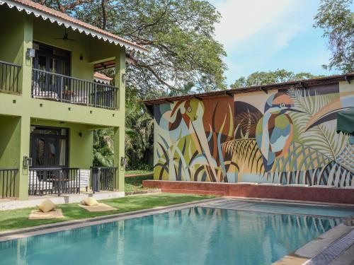 a mural on the side of a building with a swimming pool at The Project Cafe and Hotel in Aldona