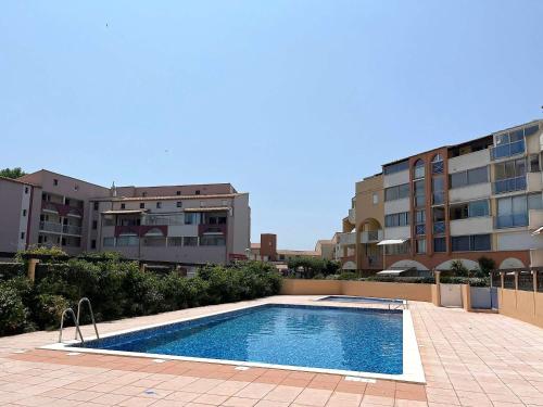 - une piscine en face de certains bâtiments dans l'établissement Splendide T3 près de la mer avec piscine, parking et Wi-Fi - FR-1-607-206, au Cap d'Agde