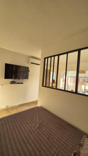 une chambre avec un lit et une télévision à écran plat dans l'établissement Port de Hyères appartement 4 personnes et parking, à Hyères