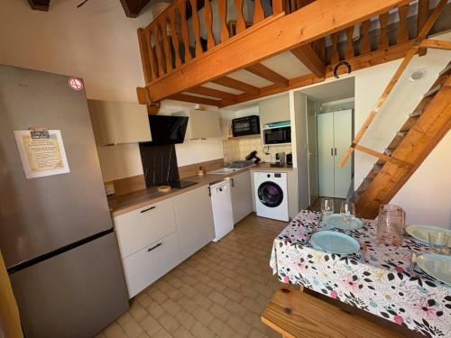 une cuisine avec une table et un réfrigérateur dans l'établissement Maison pour 6 à Saint Pierre la Mer avec piscine et espace extérieur - FR-1-229D-152, à Fleury