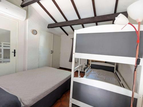 une chambre avec deux lits superposés dans une pièce dans l'établissement Appartement lumineux à Marseillan, climatisé, parking privé, 5 pers. - FR-1-387-214, à Marseillan
