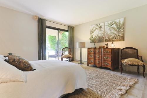 une chambre avec un lit, une commode et une fenêtre dans l'établissement Villa des Pres, à Eyragues