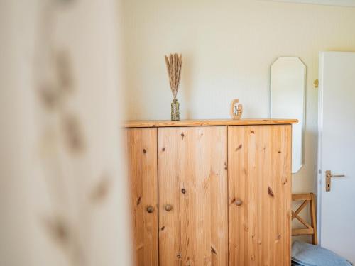 a wooden cabinet in a room with a mirror at Ferienhaus Drybarg in Simonsberg