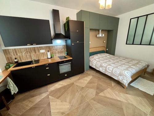 - une cuisine avec un lit et un évier dans la chambre dans l'établissement Studio ciné au cœur de Compiègne, à Compiègne