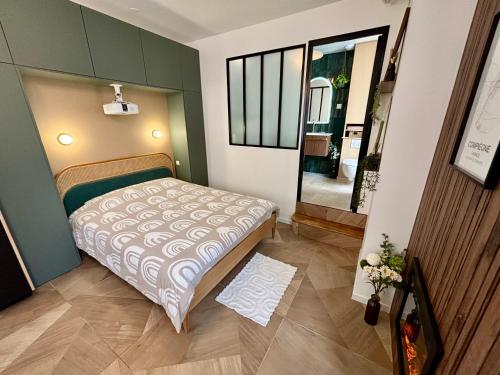 a small room with a bed and a mirror at Studio ciné au cœur de Compiègne in Compiègne