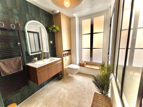 a bathroom with a sink and a toilet and a mirror at Studio ciné au cœur de Compiègne in Compiègne