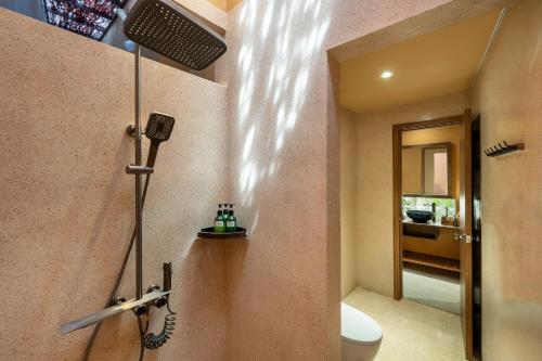 a bathroom with a shower with a toilet and a sink at Qvilla Sand, An Bang beach, Hoi An in An Bàn (2)