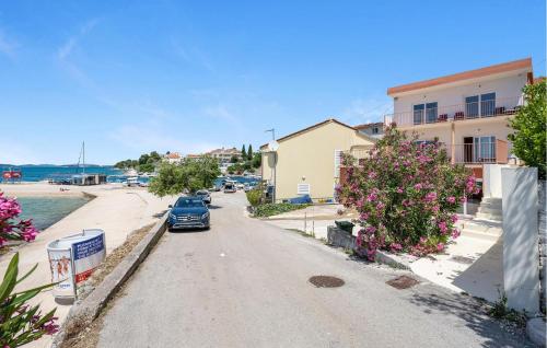 a car parked on the side of a street with flowers at 2 Bedroom Nice Apartment In Brodarica in Brodarica