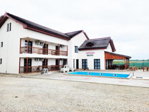 a building with a swimming pool in front of it at Lotusul Deltei in Murighiol