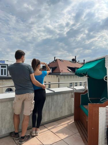 a man and a woman standing on a roof at Unsöld's Factory Hotel in Munich