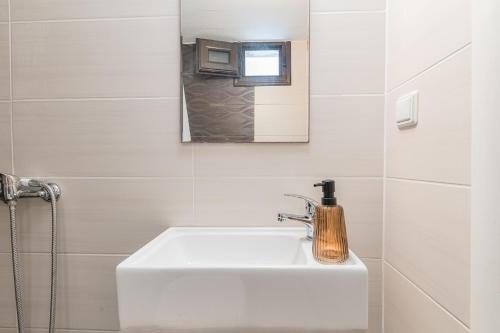 Un baño con un lavabo blanco y un espejo. en Zendaya studios, en Polychrono