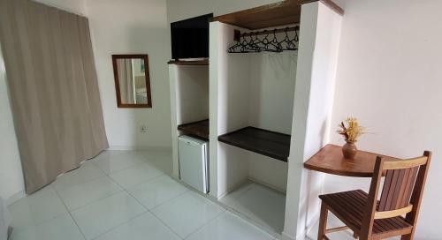 a room with a table and a chair and a closet at Hotel Malibu in Porto Seguro
