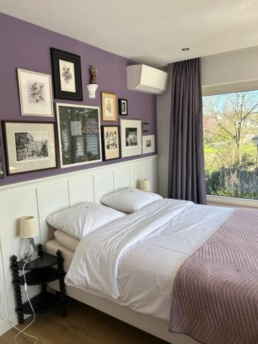 a bedroom with a white bed and pictures on the wall at Boutiquehotel B&B the SJinn in Schin op Geul