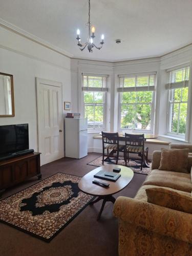 a living room with a couch and a table at Kenmuire Apartment in Weymouth