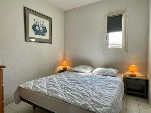 une chambre avec un lit avec deux lampes et une fenêtre dans l'établissement Appartement 2P / cabine, proche plage, parking privatif - FR-1-225-59, à Argelès-sur-Mer
