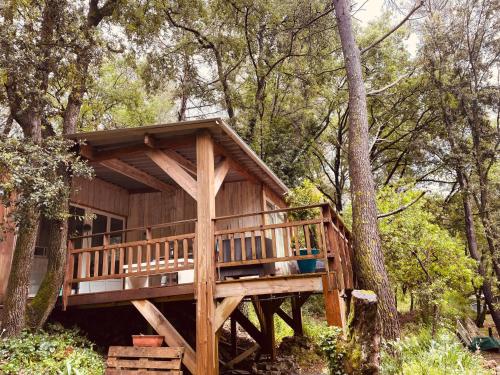 a tree house with a deck in the woods at Le chalet du Rêveur in La Gaude