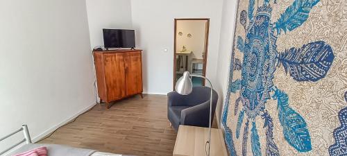 a living room with a chair and a tv at Apartment 1 in Altstadt in Angermünde in Angermünde