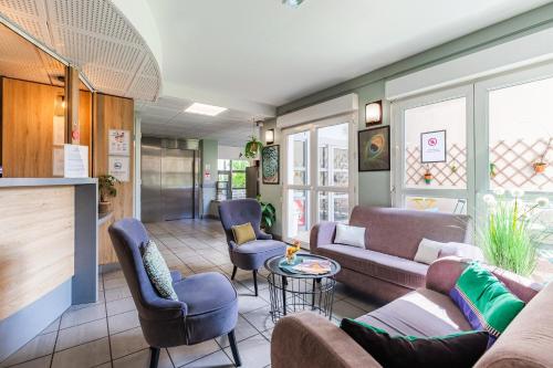 a lobby with couches and chairs and a table at Appart'City Classic Lyon Villeurbanne in Villeurbanne