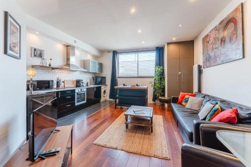 un salon avec un canapé et une cuisine dans l'établissement Loft Lamoricière - 15 minutes à pieds du centre, à Nantes