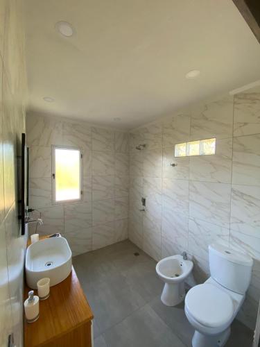 a bathroom with a toilet and a sink at Alojamiento la irene in Paso de la Patria